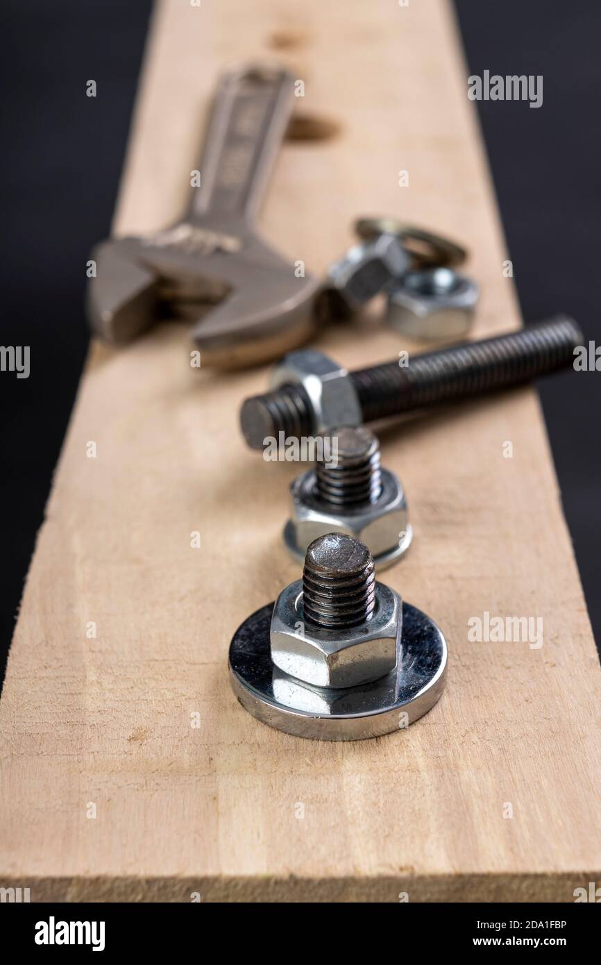 Metal bolts and nuts for joining wood. Tightening the screws with an