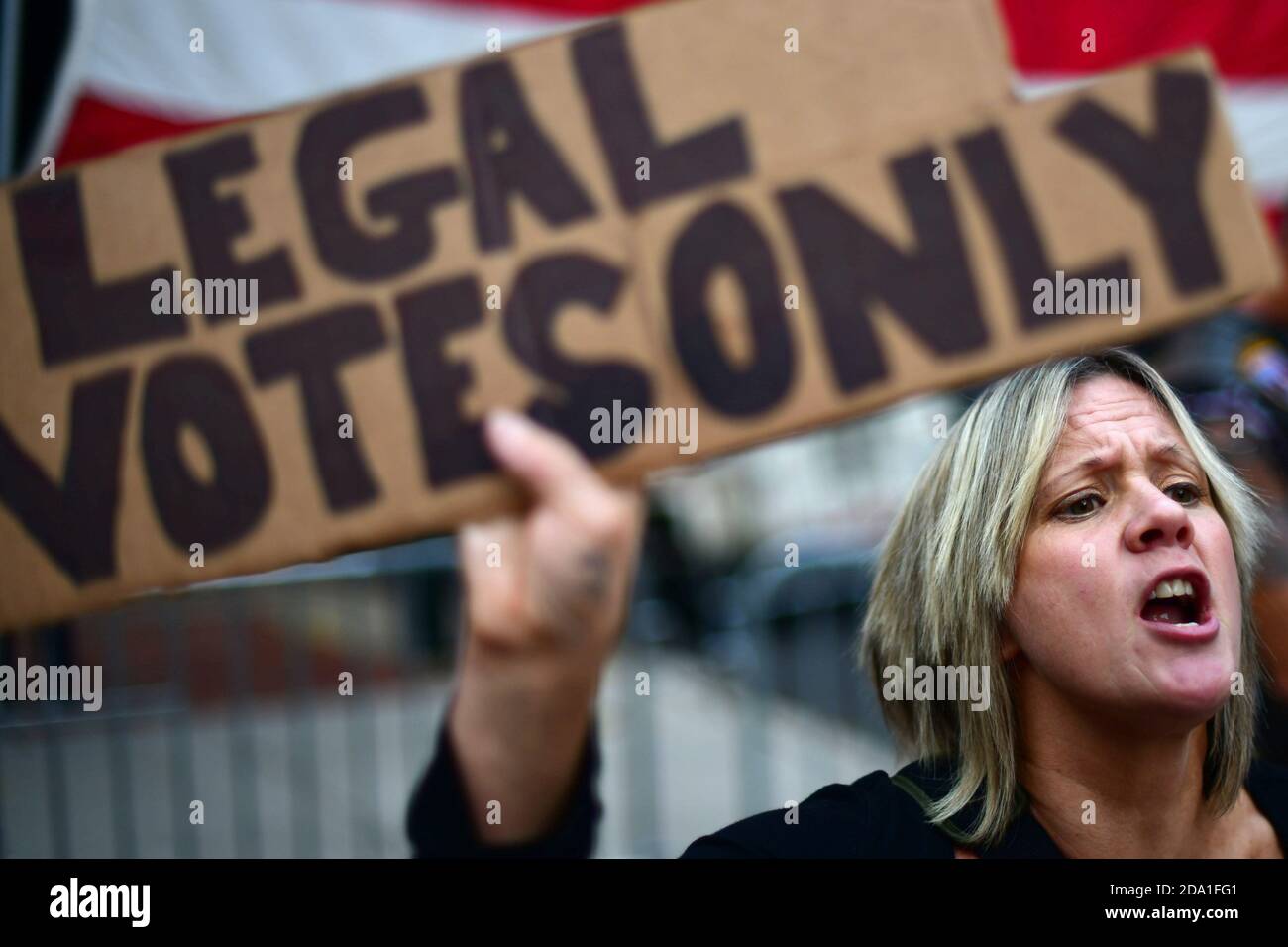 Carri Dusza, a supporter of President Donald Trump, holds a placard stating 'LEGAL VOTES ONLY' while shouting across the street at supporters of President-elect Joe Biden the day after a presidential election victory was called for Biden, in Philadelphia, Pennsylvania, U.S. November 8, 2020. REUTERS/Mark Makela Stock Photo