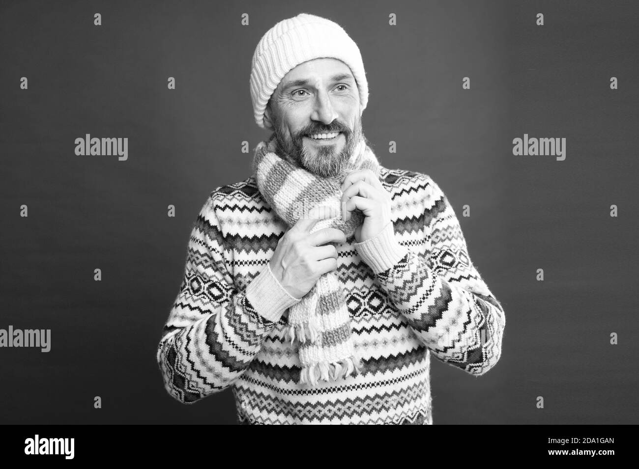 Dressing like man. Mature man red background. Bearded man in winter style. Caucasian man wear warm clothes. Fashion and style. Winter trends. Stock Photo