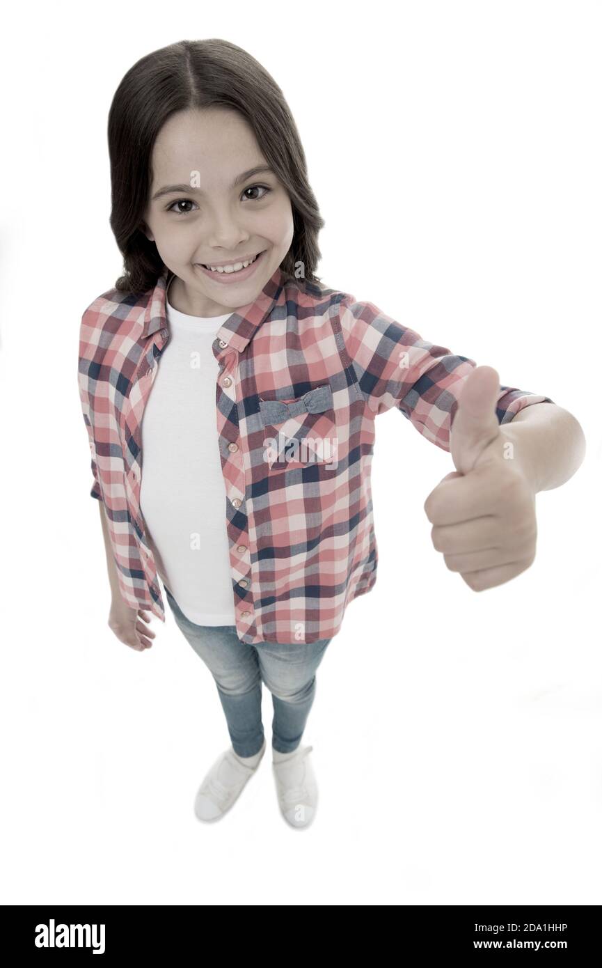 I like it. Kid girl long curly hair posing confidently. Girl smiling face feels confident. Child confidently showing thumbs up. Upbringing confidence concept. Feel so confident with parental support. Stock Photo