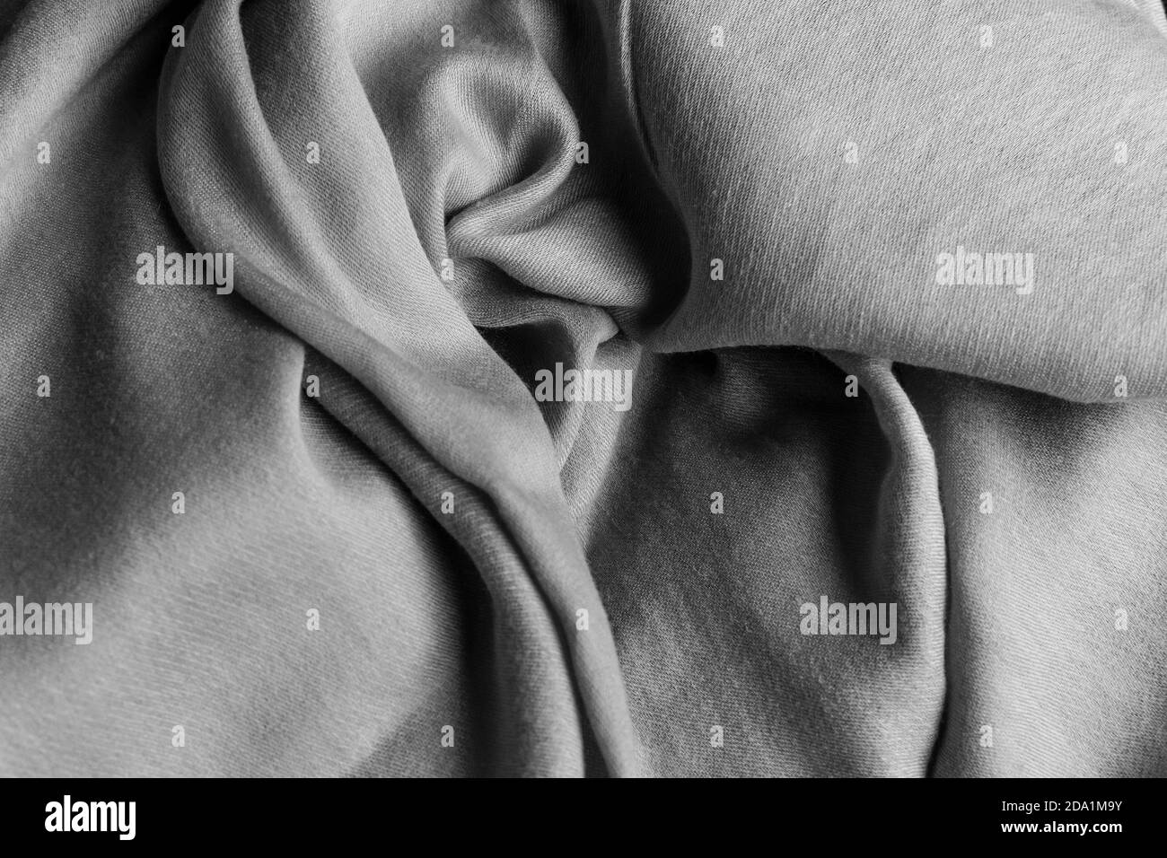 black and white silk fabric, grey textile on the table, flatlay of a clothing material, softness and elegance, selective focus Stock Photo