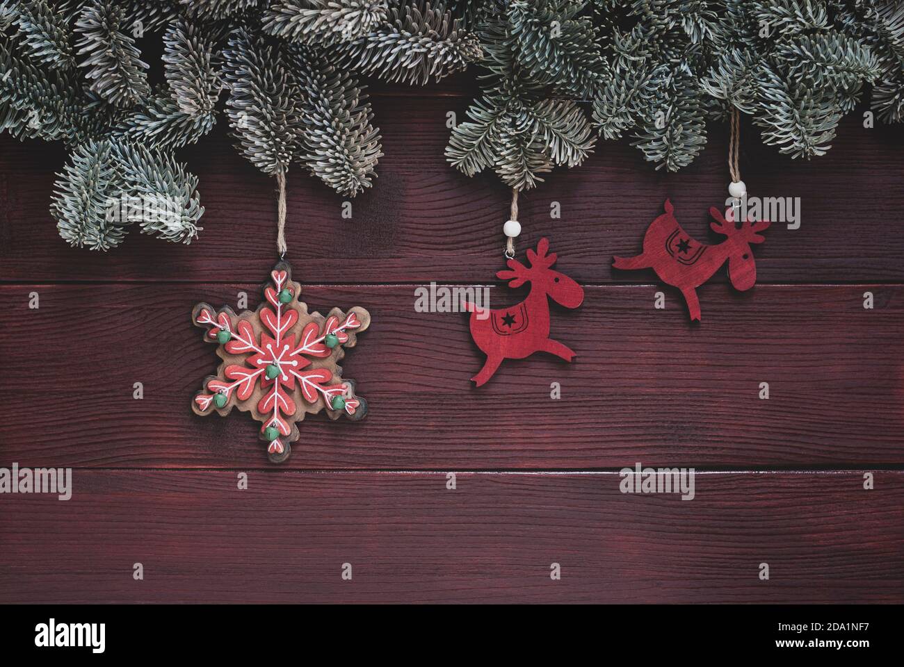 winter holidays traditional ornaments, christmas background with spruce twigs border, deers and snowflake decorations Stock Photo