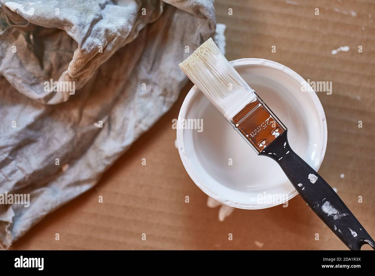 Paint brush on a can of white wall paint Stock Photo - Alamy