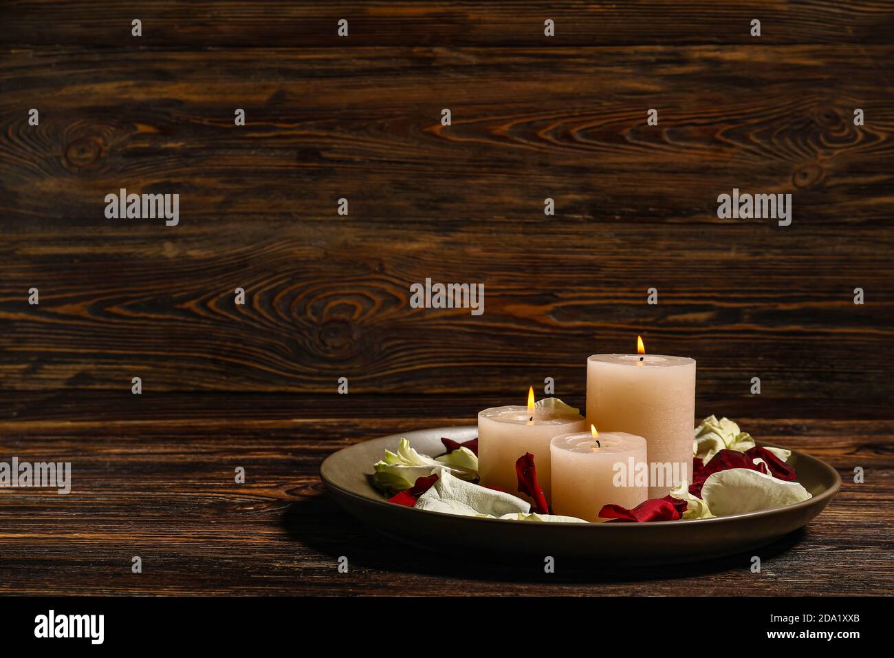 Tray with burning candles and flower petals for celebration of Divaly on wooden background Stock Photo