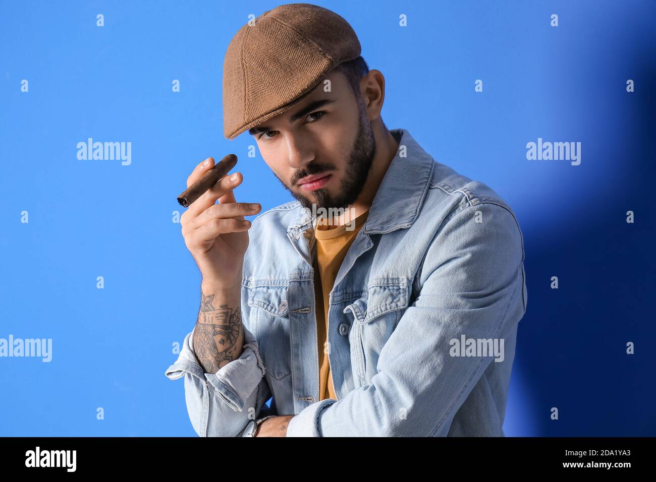Fashionable young man on color background Stock Photo