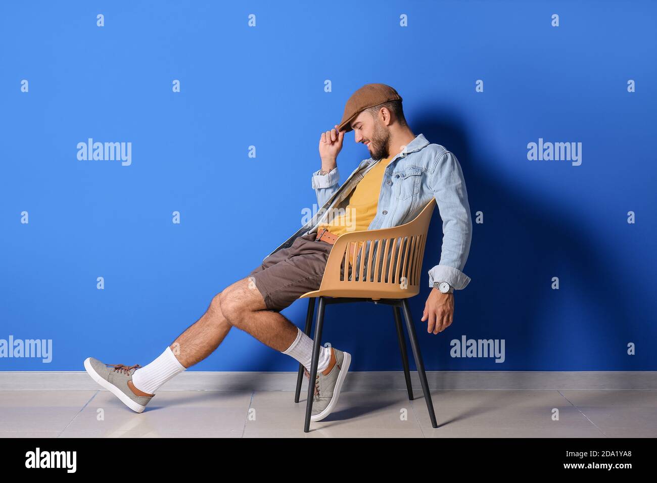Fashionable young man on color background Stock Photo