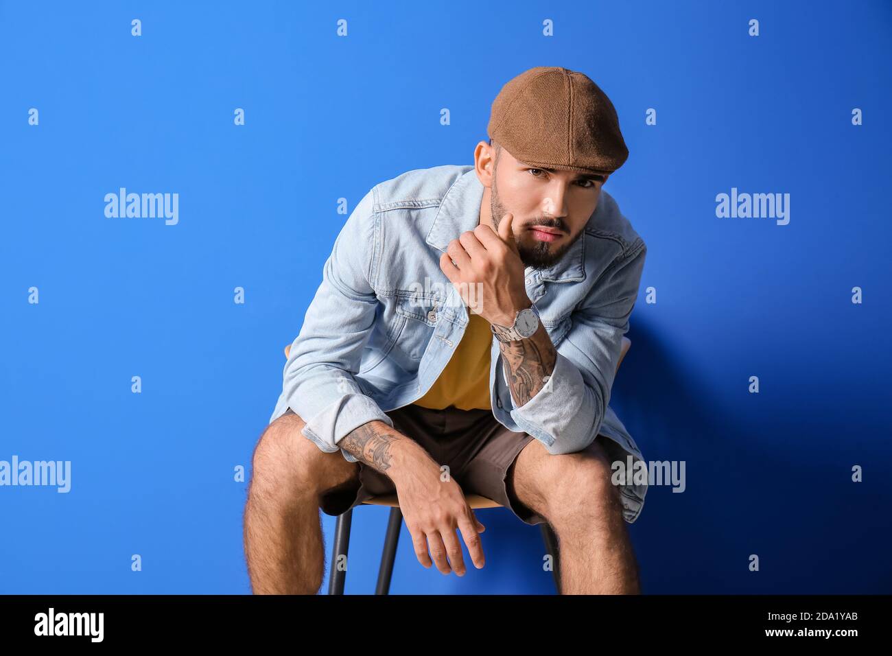Fashionable young man on color background Stock Photo