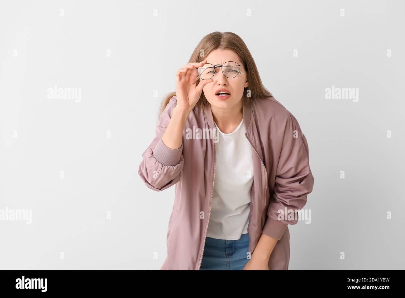 Woman with problem of poor eyesight on light background. Diabetes
