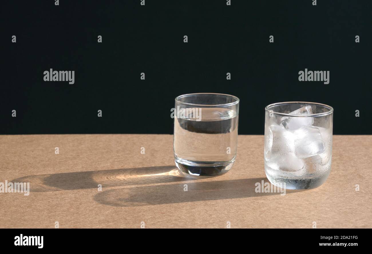 Glass of water and glass of ice cubes on table. Copy space. Stock Photo