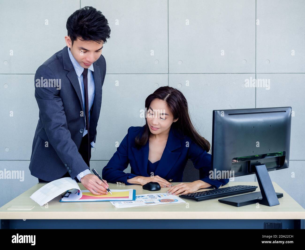 Asian business woman and businessman wearing suit working together in