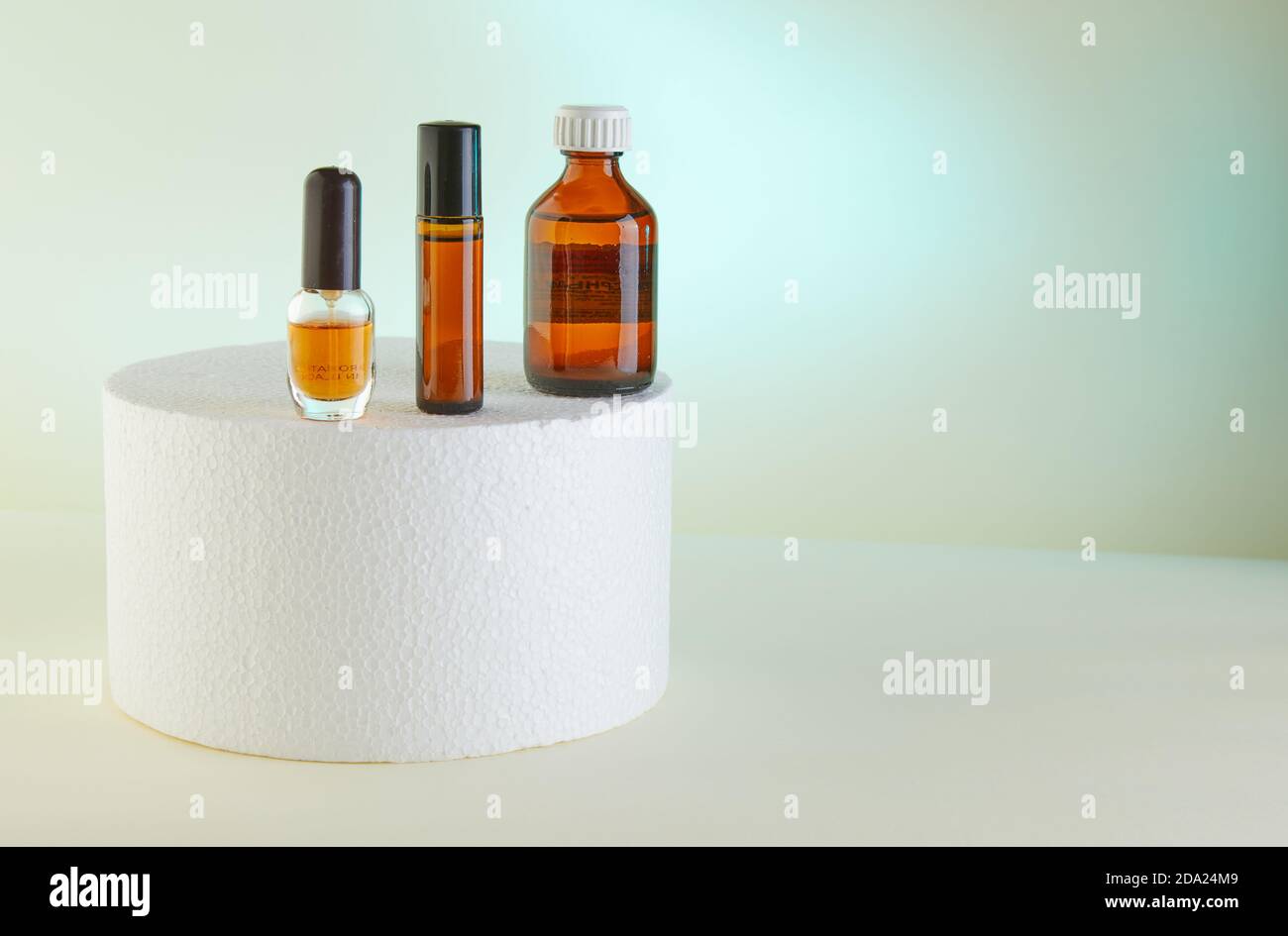 Dropper Bottle - Amber Glass of perfume, shower gel, unlabeled bottles on white podium. Stock Photo