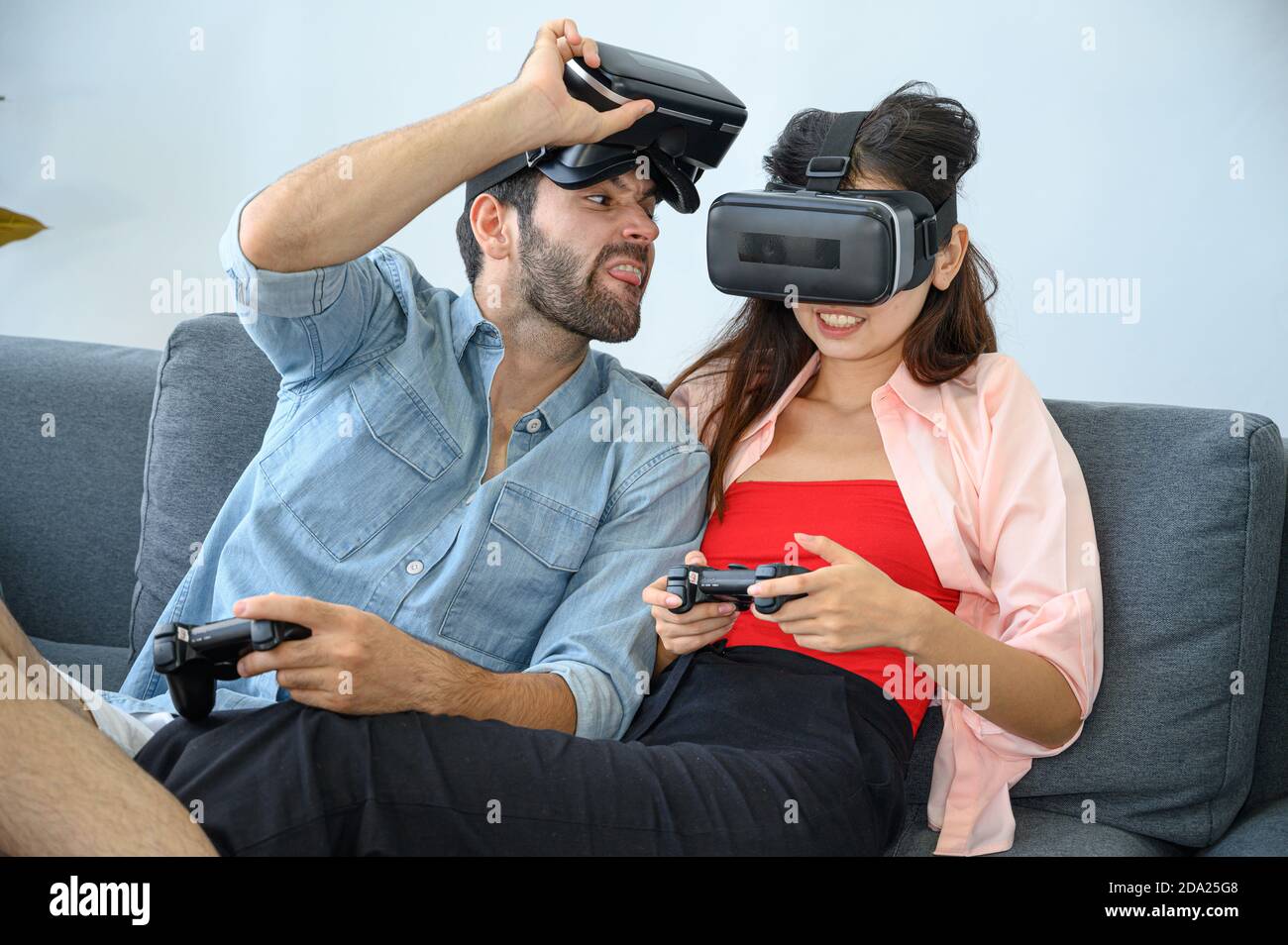 Couple lovers enjoy  playing VR game together at home. Family relationship concept. Stock Photo