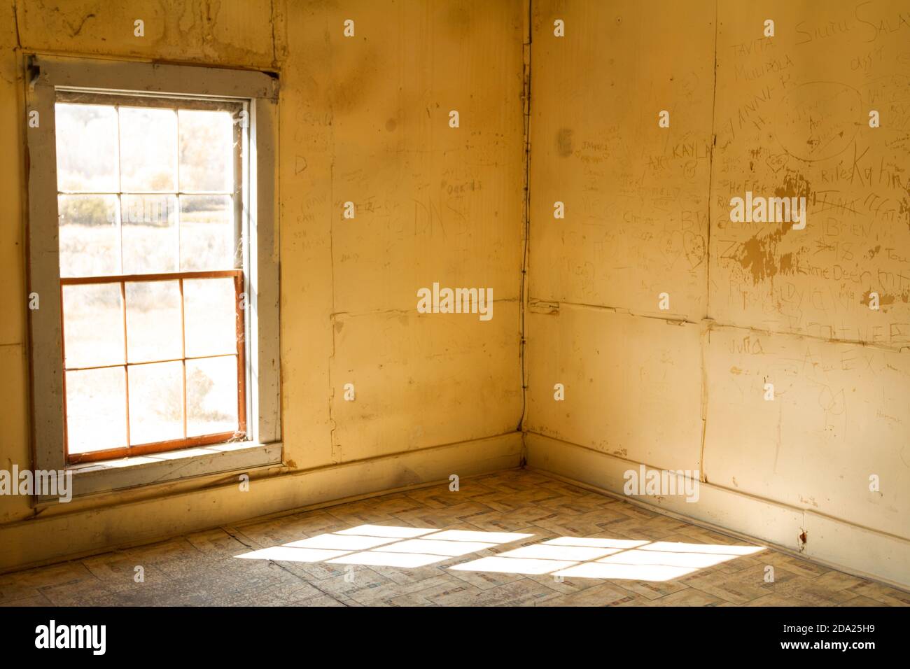 Empty room with light casting shadow on a barren floor. Decrepit, solemn, lonely, abandoned house. Bannack ghost town, Montana, USA. Stock Photo