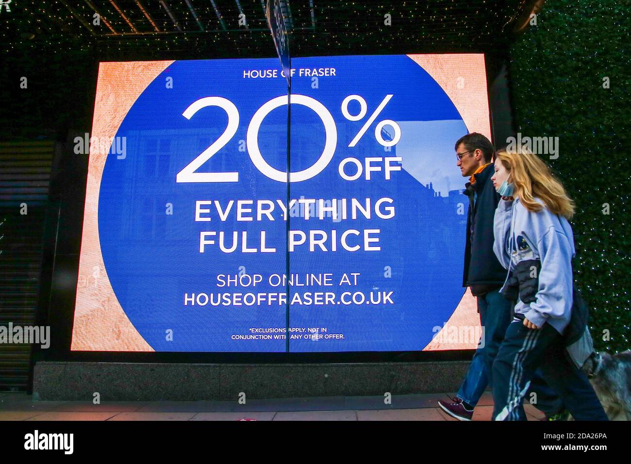 People walk past House of Fraser's Winter Sale window display on Oxford