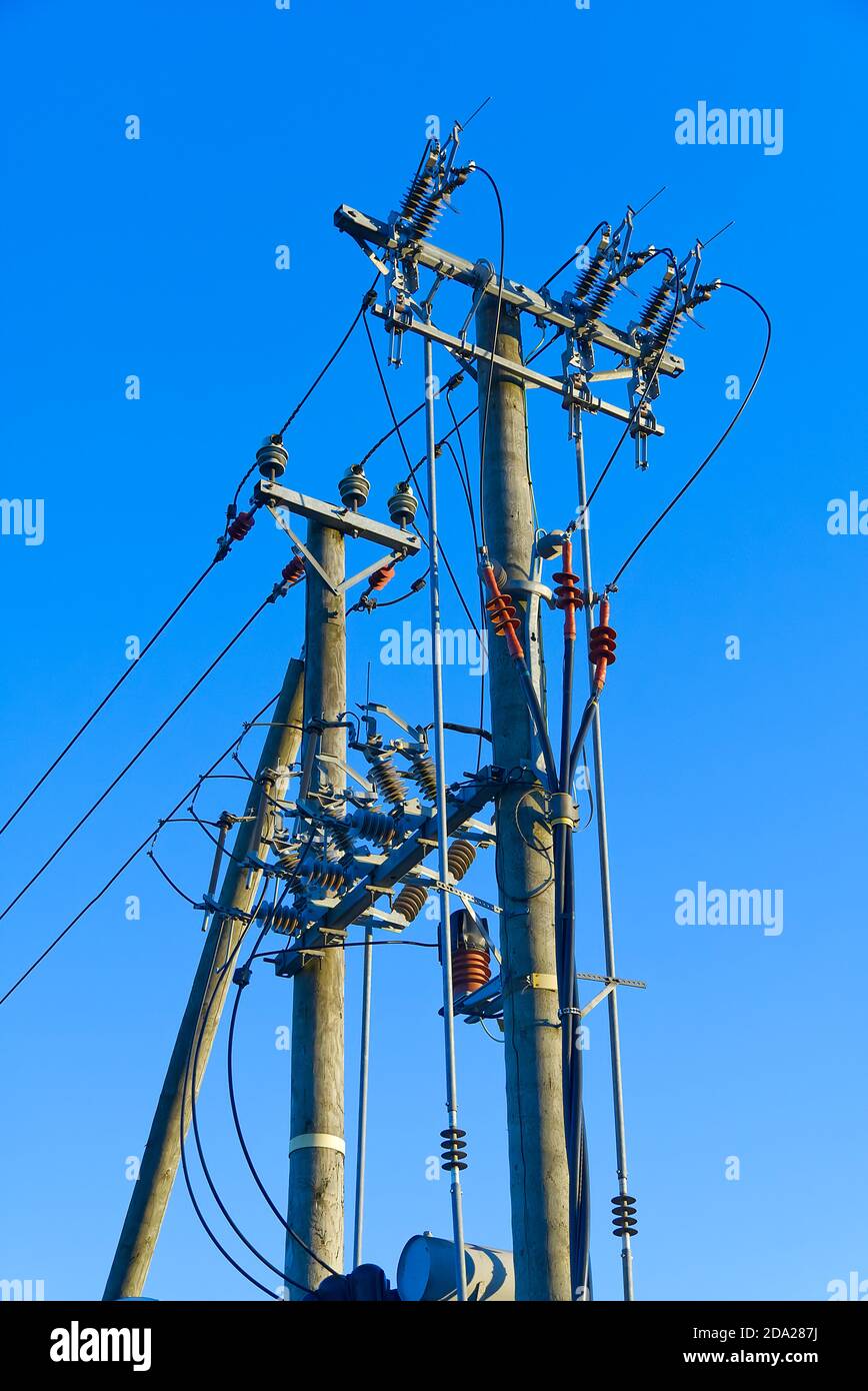 electric power sky lines and connections on a wooden post. wooden electricity post against blue sky. Electric power lines and wires with blue sky. Stock Photo