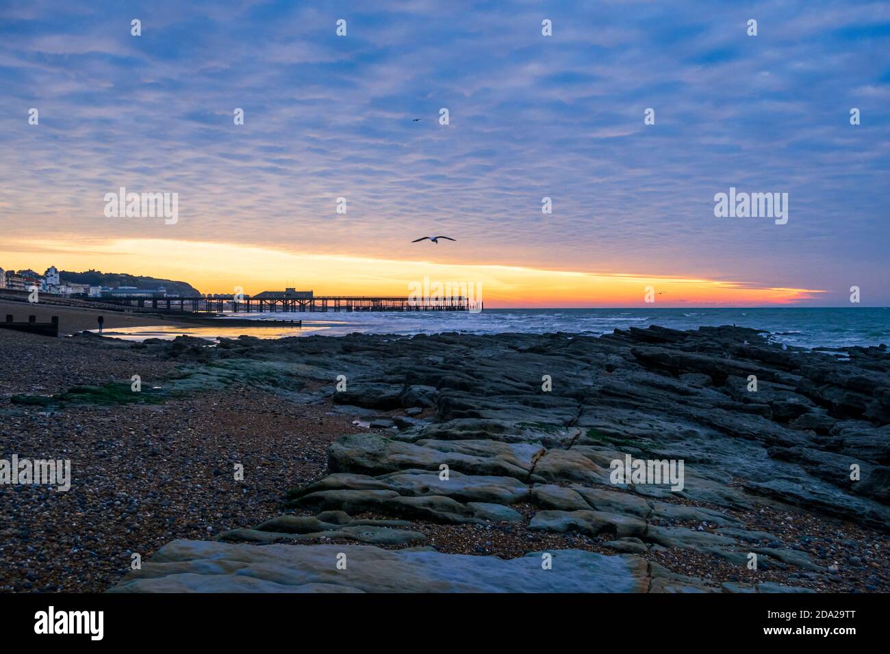 Dramatic dawn mackerel sky over Hastings pier in east Sussex south east England Stock Photo