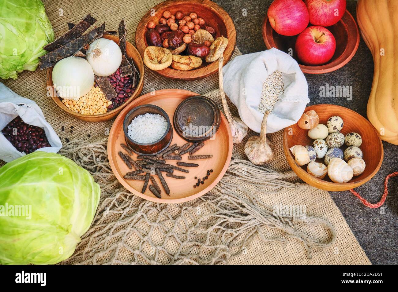 Food residents of ancient Rome on the table, reconstruction. Salt, cereals, beans, dried fruits, pumpkin and cabbage. Retro food citizens in the Roman Stock Photo