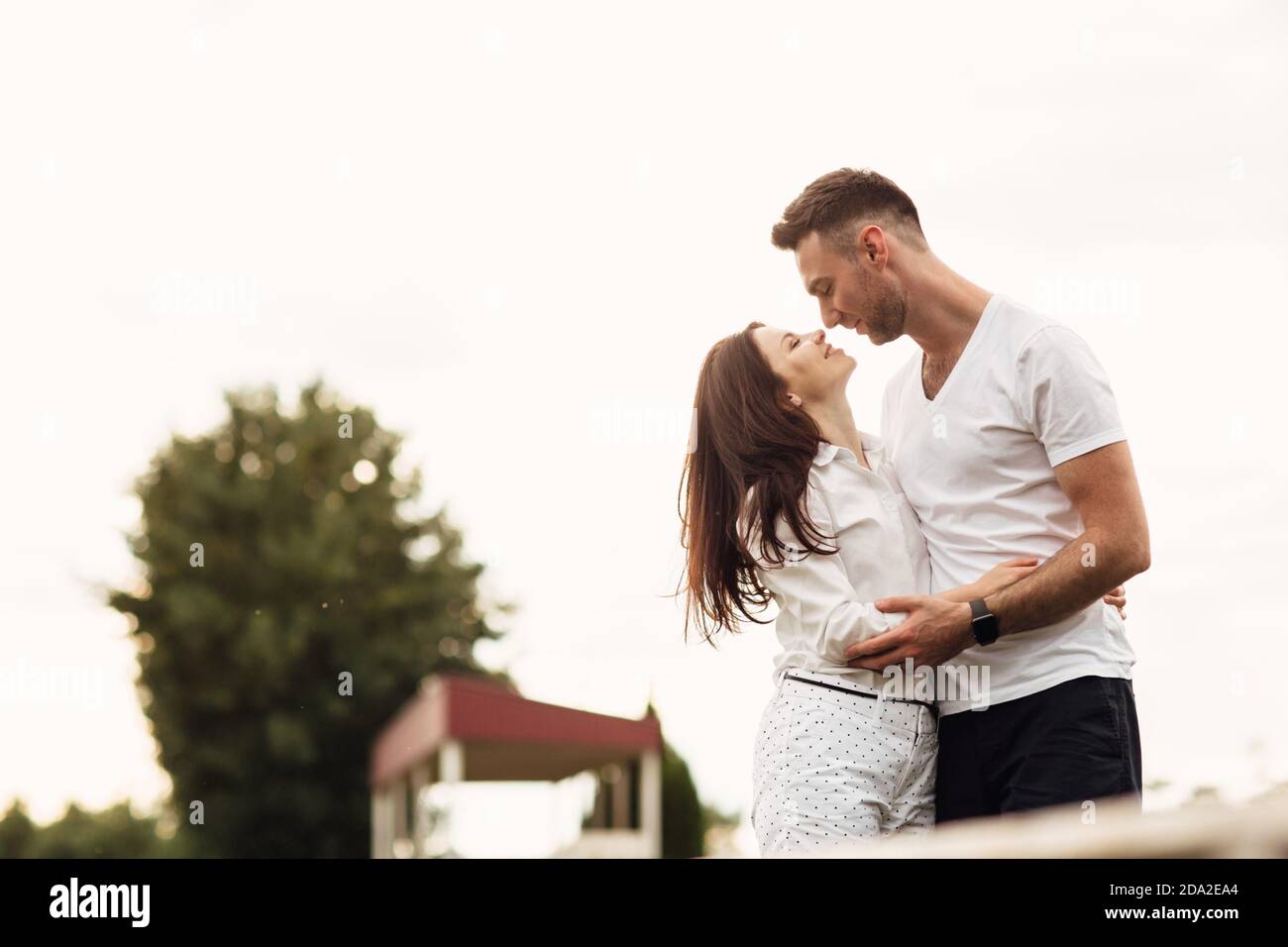 beautiful young couple hugging and kissing outdoors in the park on a ...