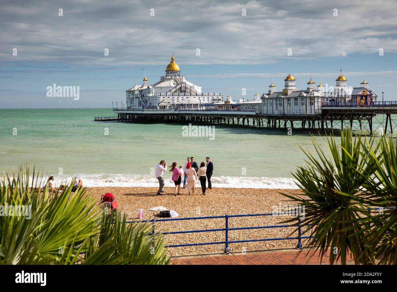 UK, England, East Sussex, Eastbourne, visitors on shingle beach near pier Stock Photo