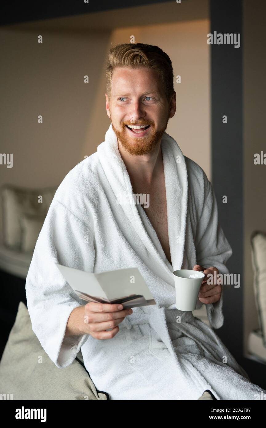 Young man drinking coffee in the morning at hotel, spa Stock Photo