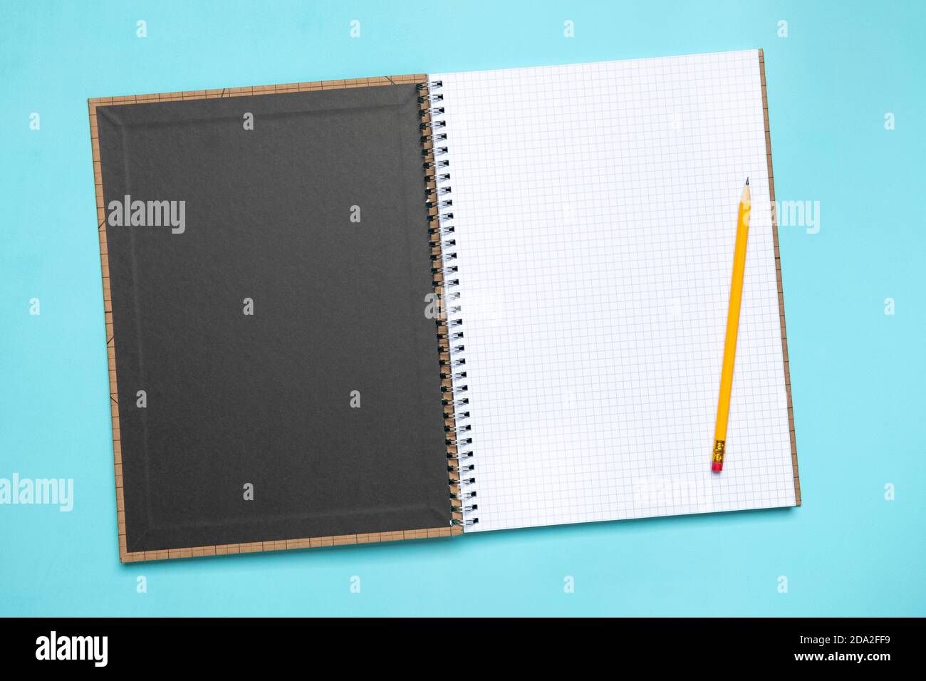 Flat lay opened blank squared notebook with yellow pencil high angle view with copy space Stock Photo