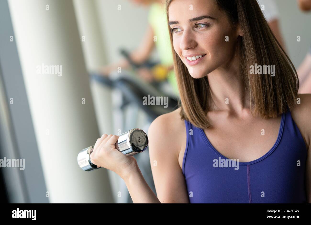 Happy fit fitness girl exercising indoor in fitness center Stock Photo