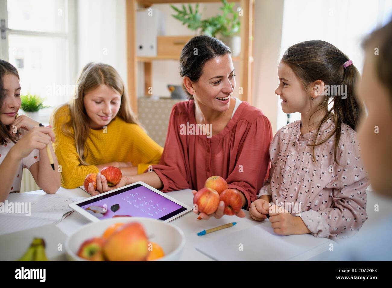 Group of homeschooling children with parent teacher studying indoors, coronavirus concept. Stock Photo