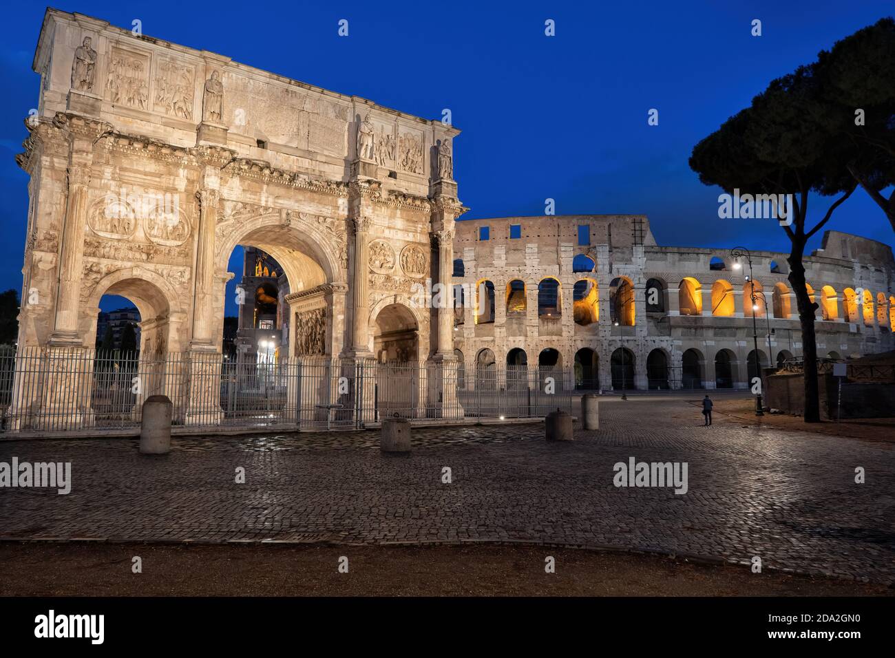 Arch of Constantine and Colosseum at night in Rome, Italy. Ancient city landmarks from Piazza del Arco di Costantino square. Stock Photo