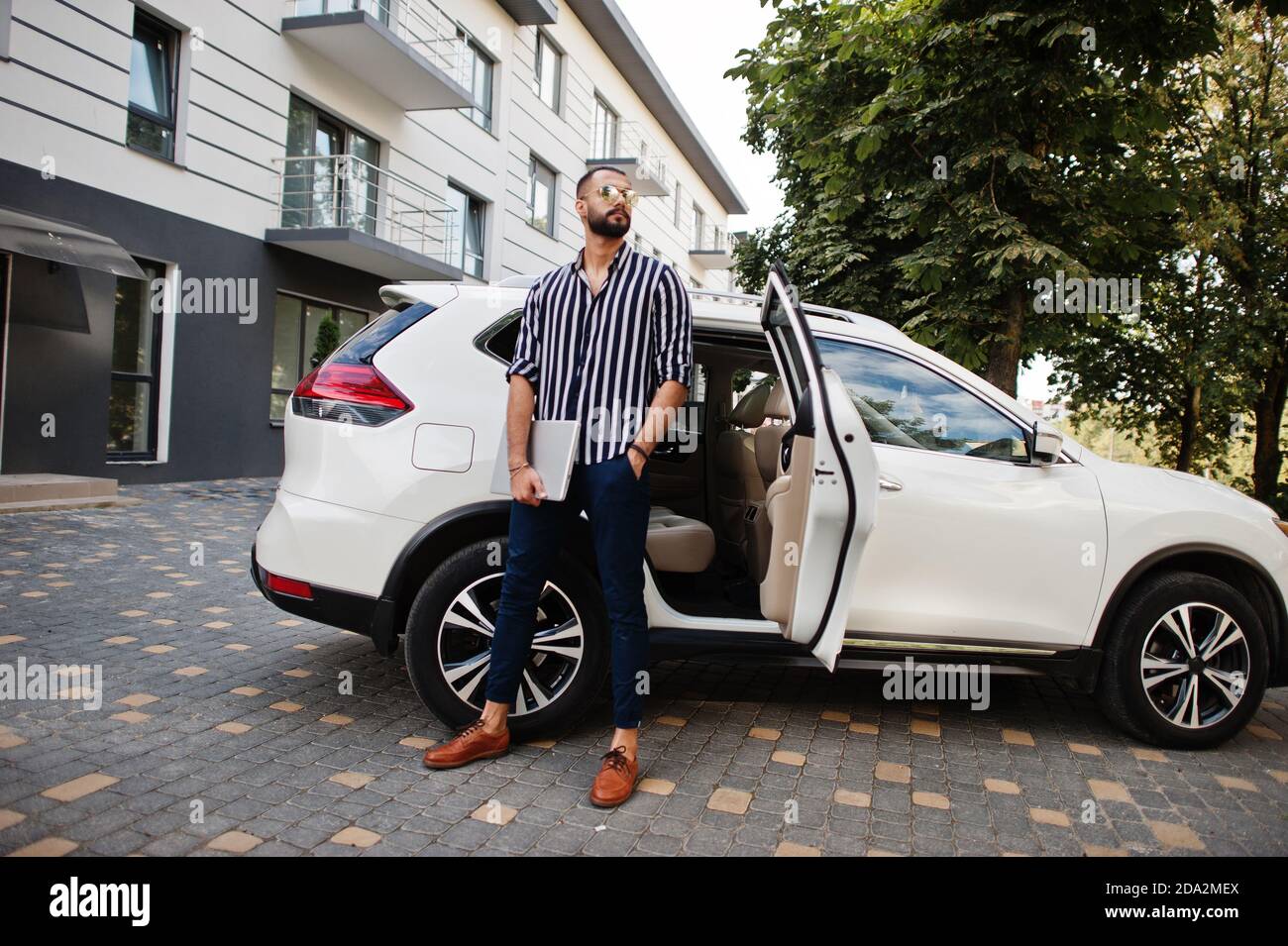 Stylish hipster arab man guy posed outdoor in street and sitting on the  trunk his black muscle car. Rich black man Stock Photo - Alamy