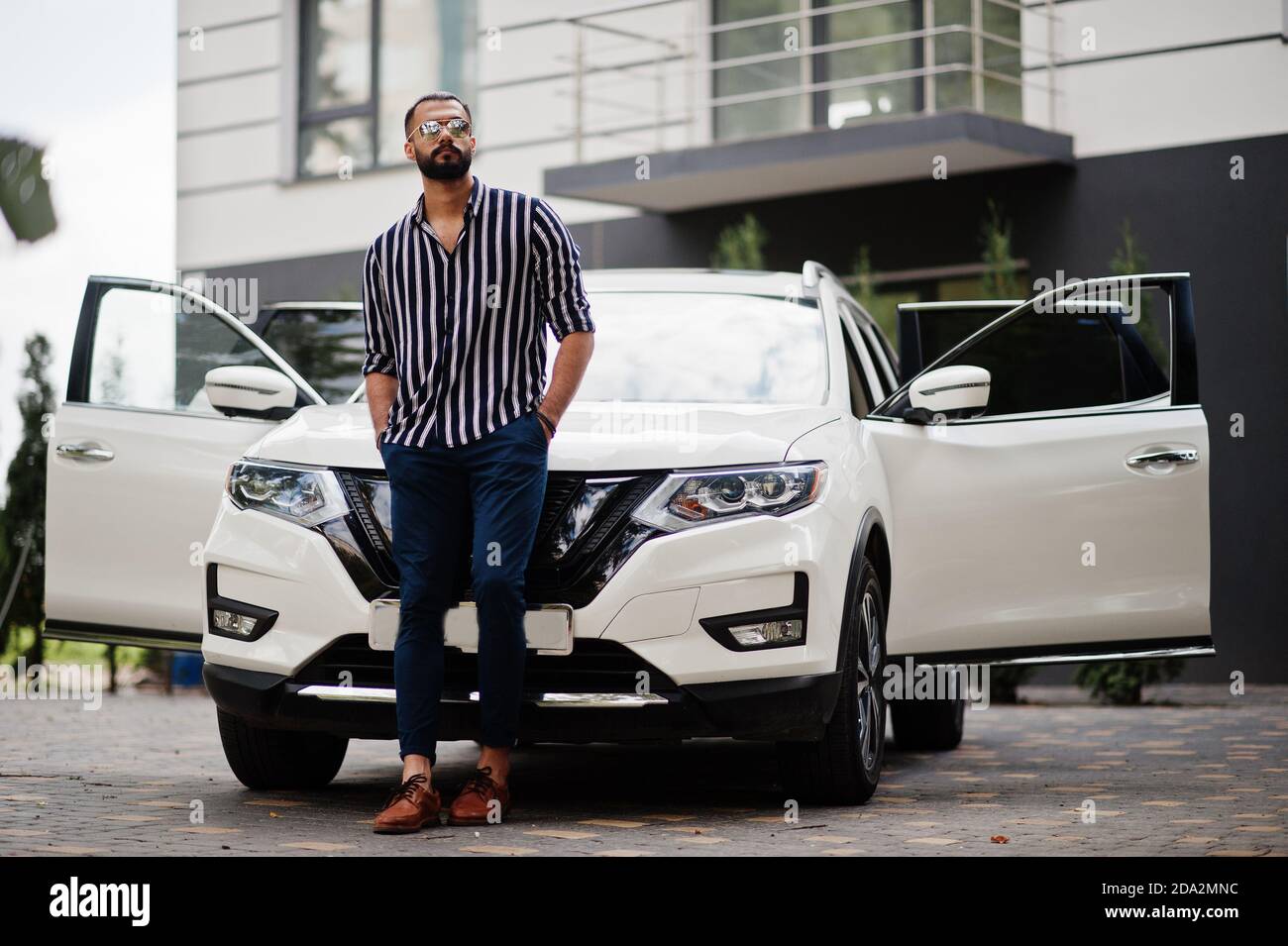 Young man poses with his car. Stock Photo | Adobe Stock