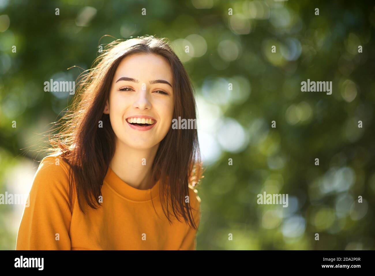 Close up portrait of smiling young woman in the park Stock Photo - Alamy