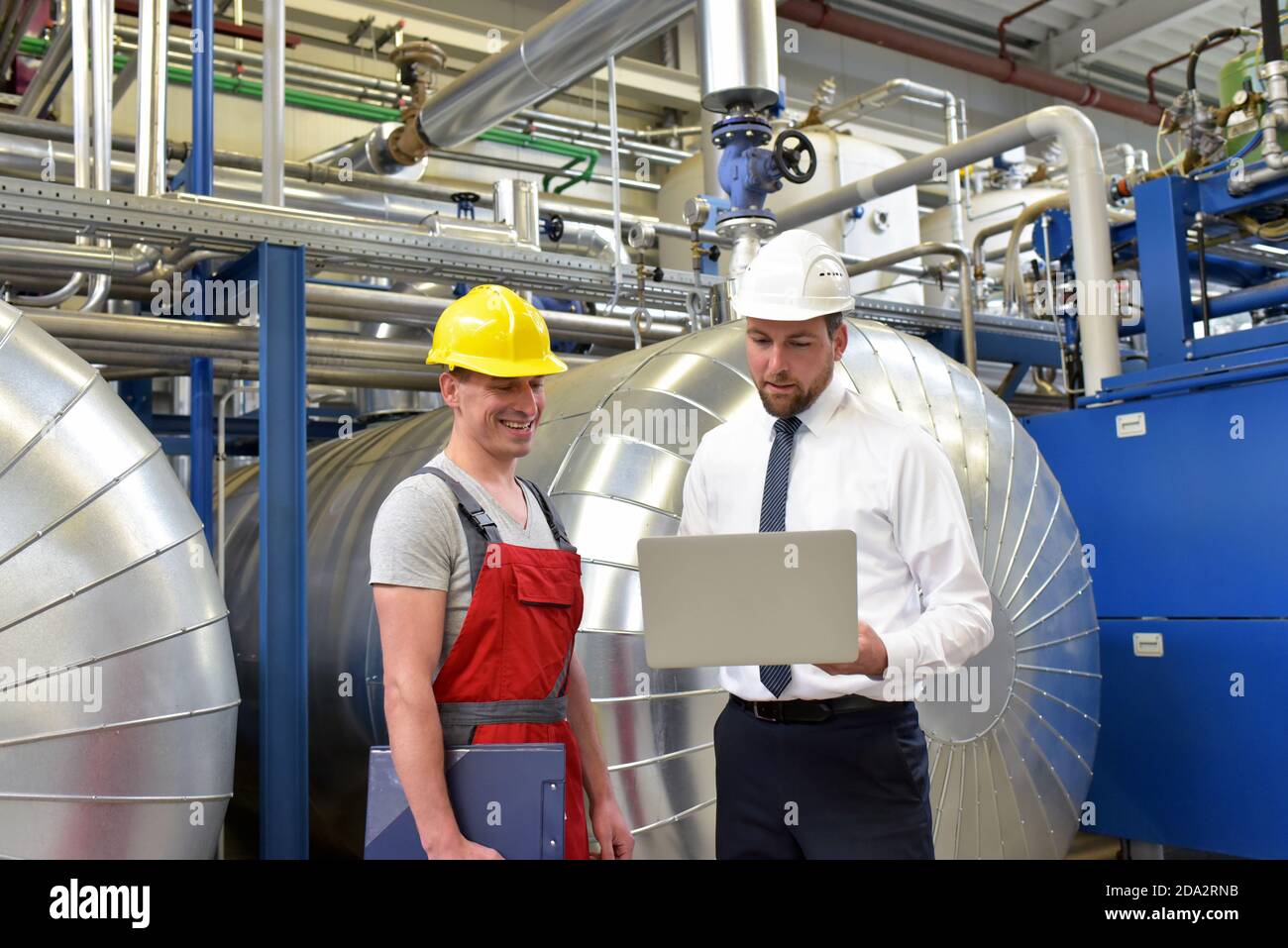 businessman and worker meeting in a factory - maintenance and repair of the industrial plant Stock Photo