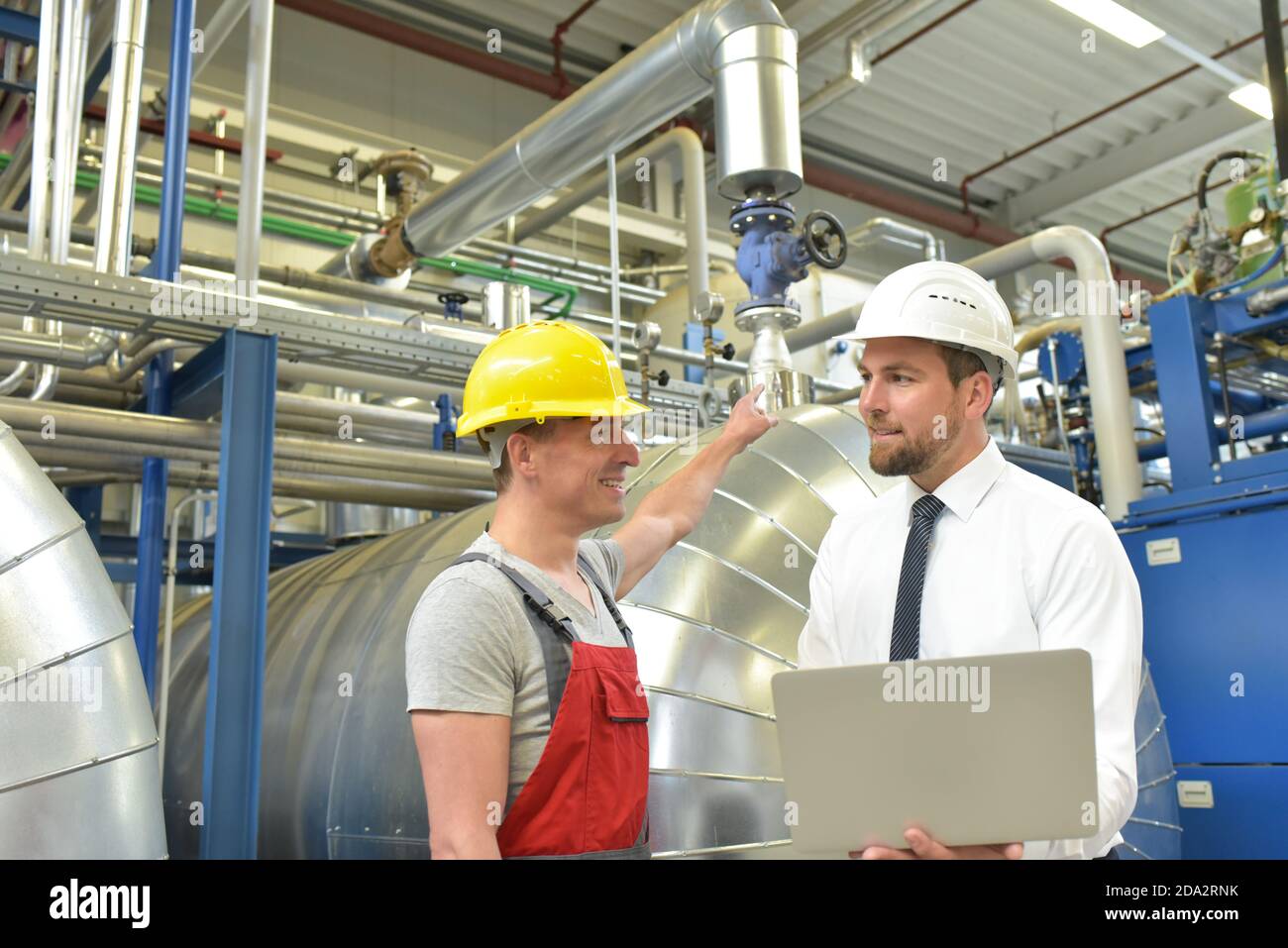 businessman and worker meeting in a factory - maintenance and repair of the industrial plant Stock Photo