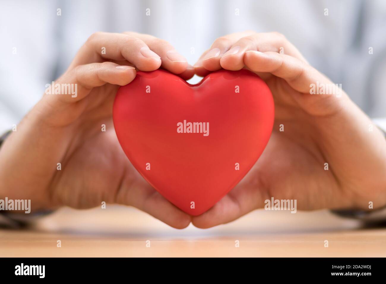 Red heart in hands. Health insurance or love concept. Stock Photo