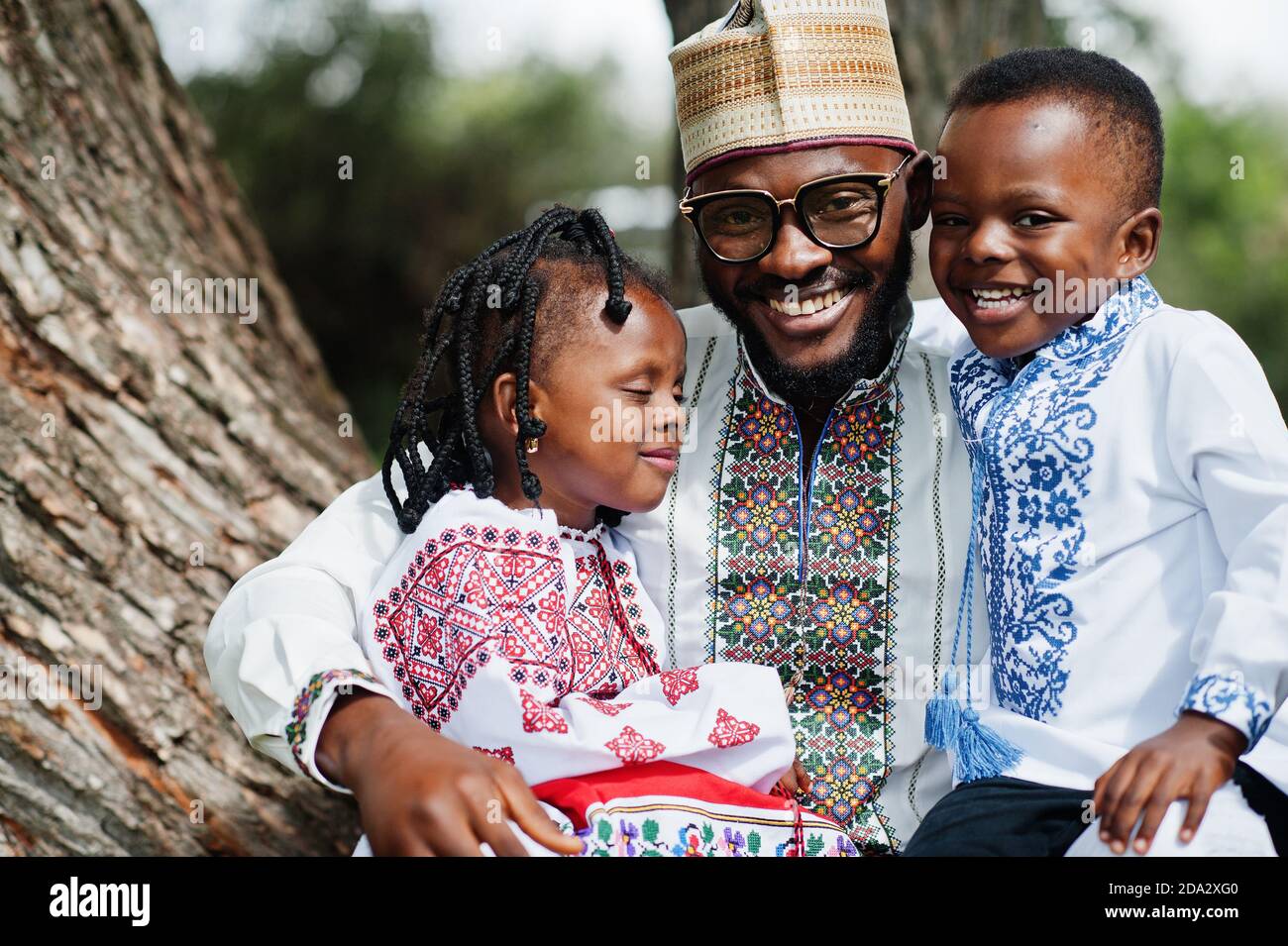 African father with kids in traditional clothes at park Stock Photo - Alamy, image size:1300x955