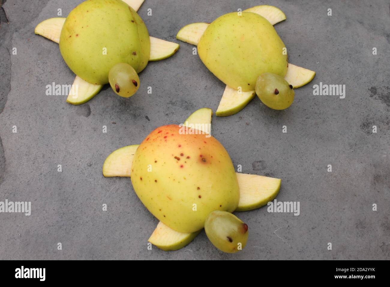 Carved apples and grapes to look like tortoise, healthy snacks for kids Stock Photo