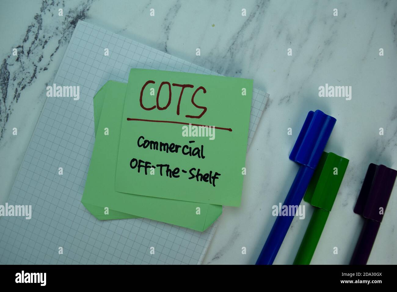 COTS Commercial OffTheShelf write on sticky note isolated on Wooden Table. Business Concept