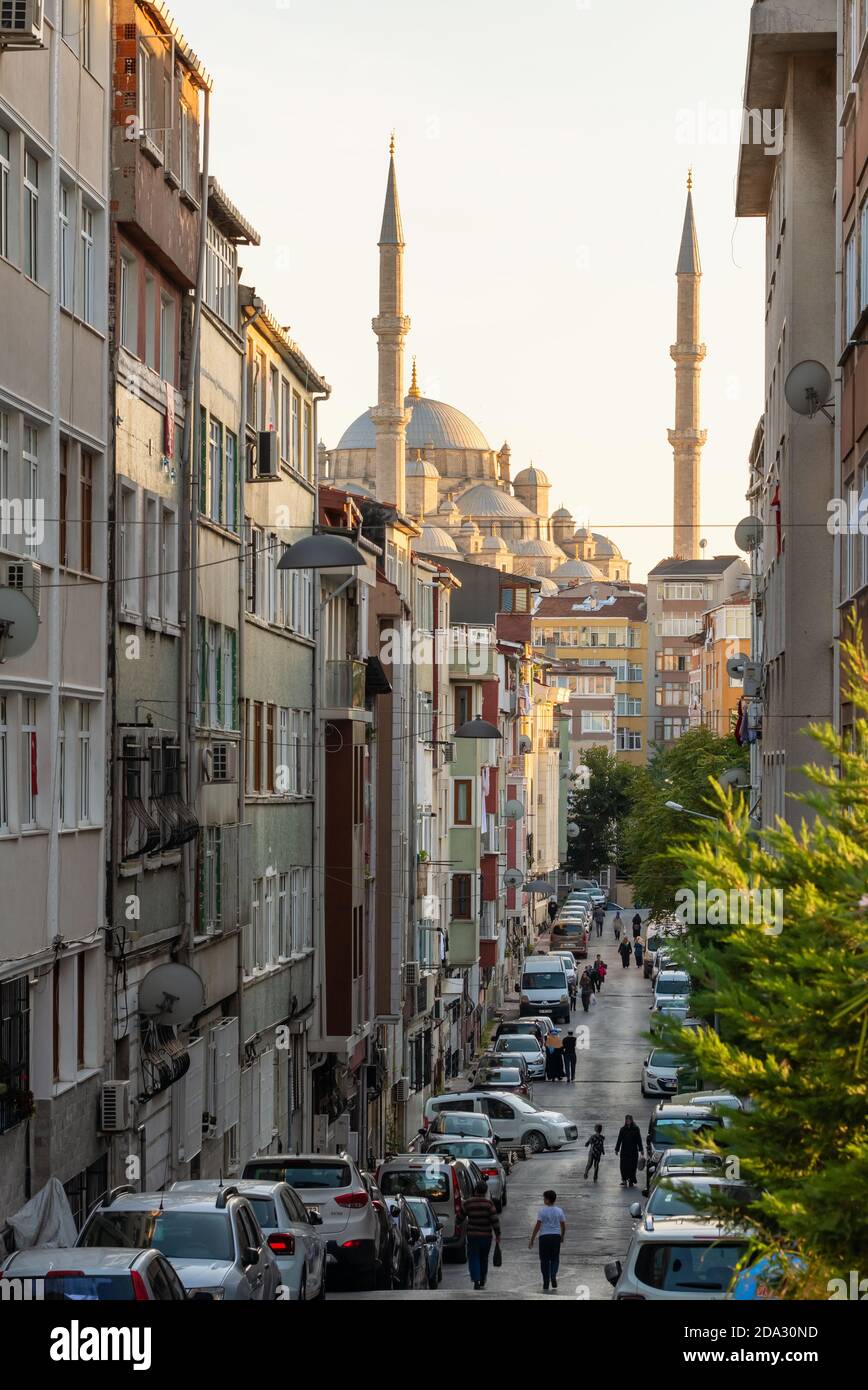 Street in residential district of Istanbul with Fatih Camii mosque at background, Turkey Stock Photo