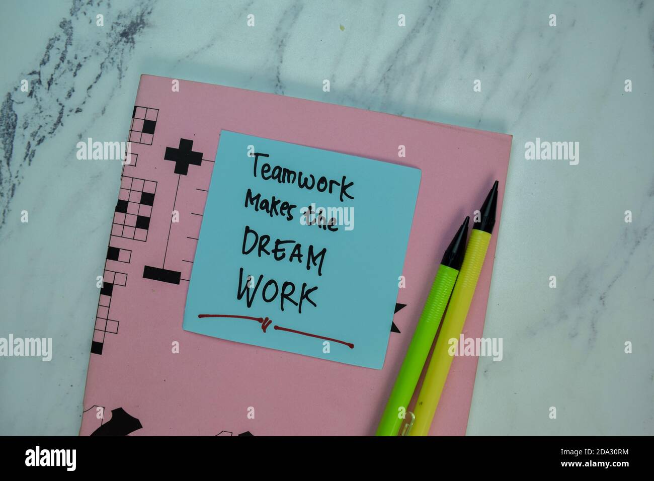 Teamwork Makes The Dream Work write on sticky note isolated on Wooden Table. Motivation concept Stock Photo