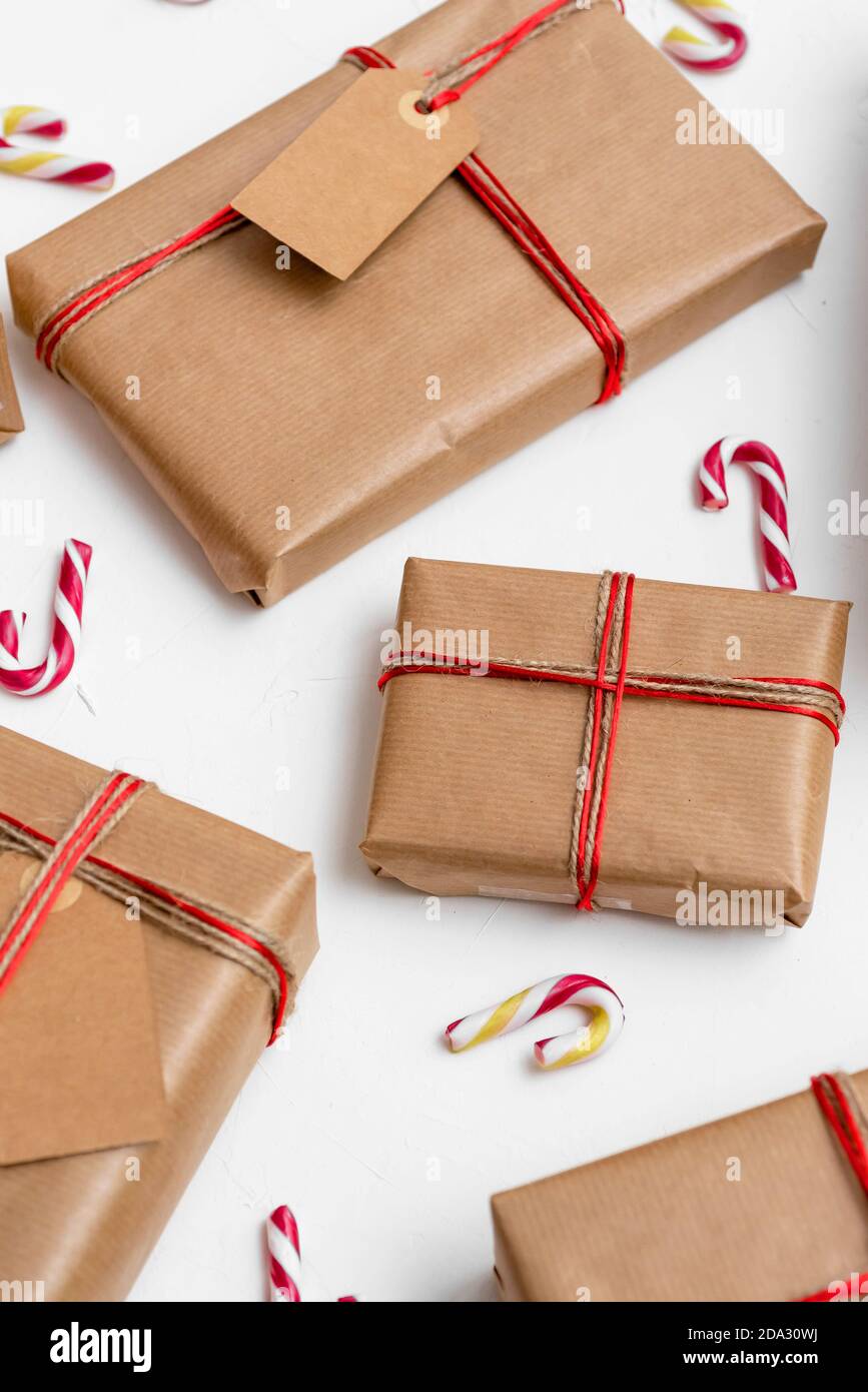 Christmas gift boxes wrapped in craft paper with red string and candy ...