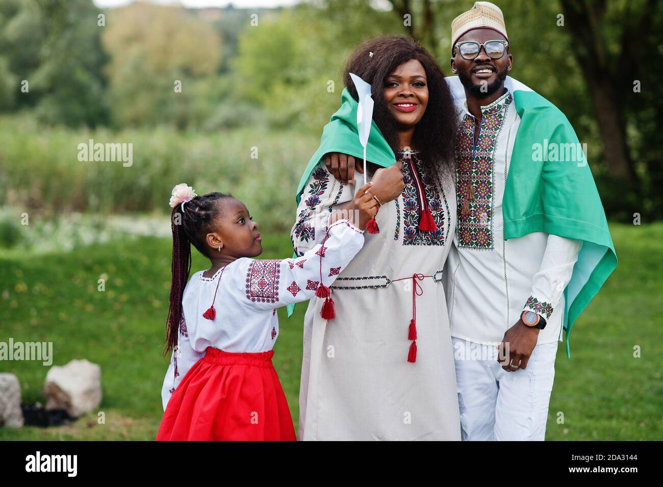 African family in traditional clothes with nigerian flags at park Stock  Photo - Alamy, image size:1300x955