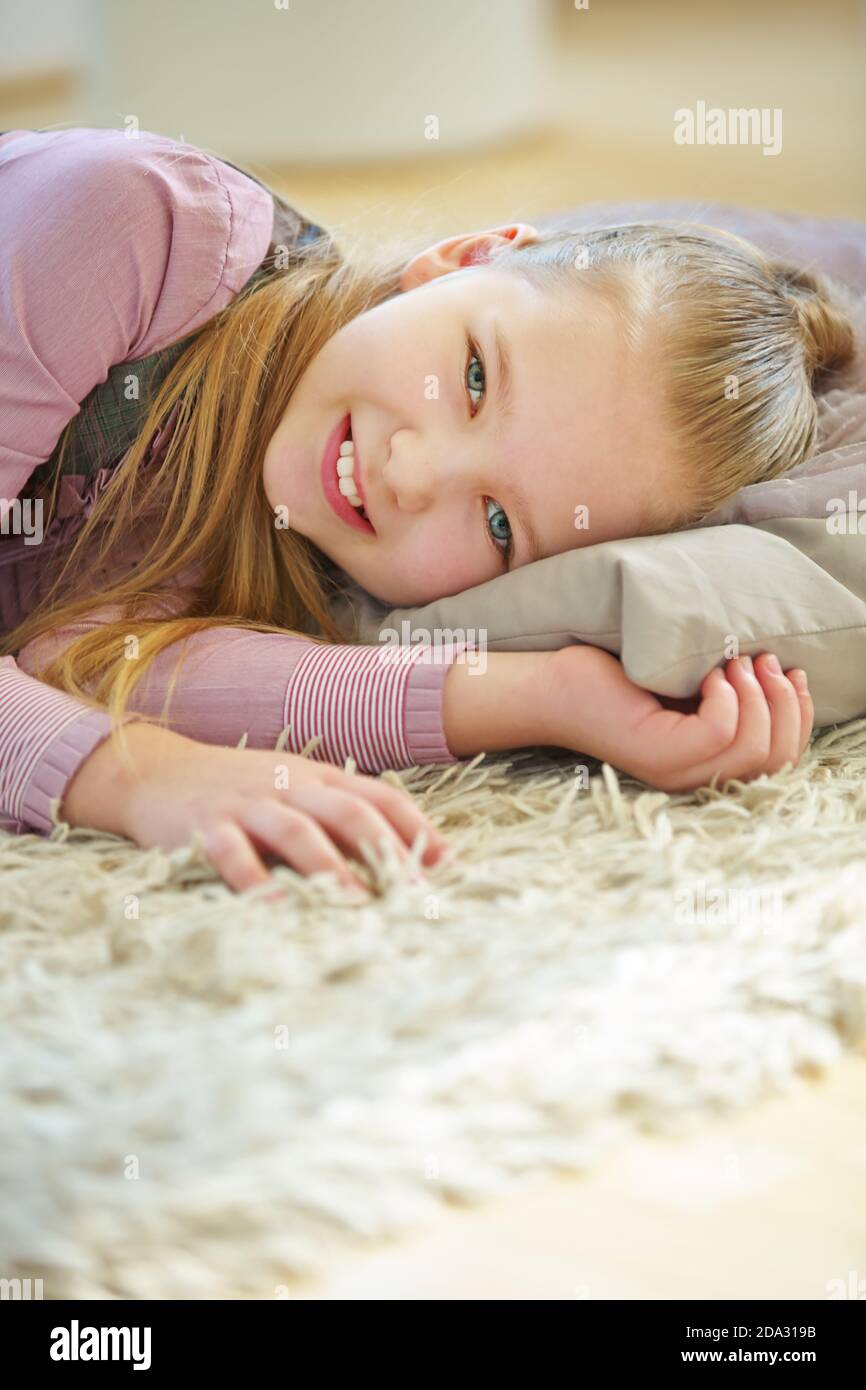 Girl lies on a pillow in the nursery for relaxation Stock Photo