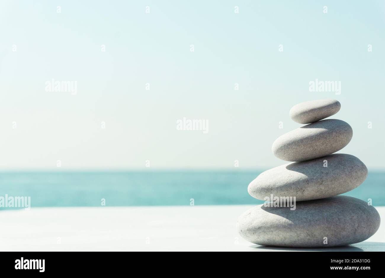 Zen relax background. A pyramid of stones on the beach in clear sunny weather. Background for meditation, yoga and massage Stock Photo