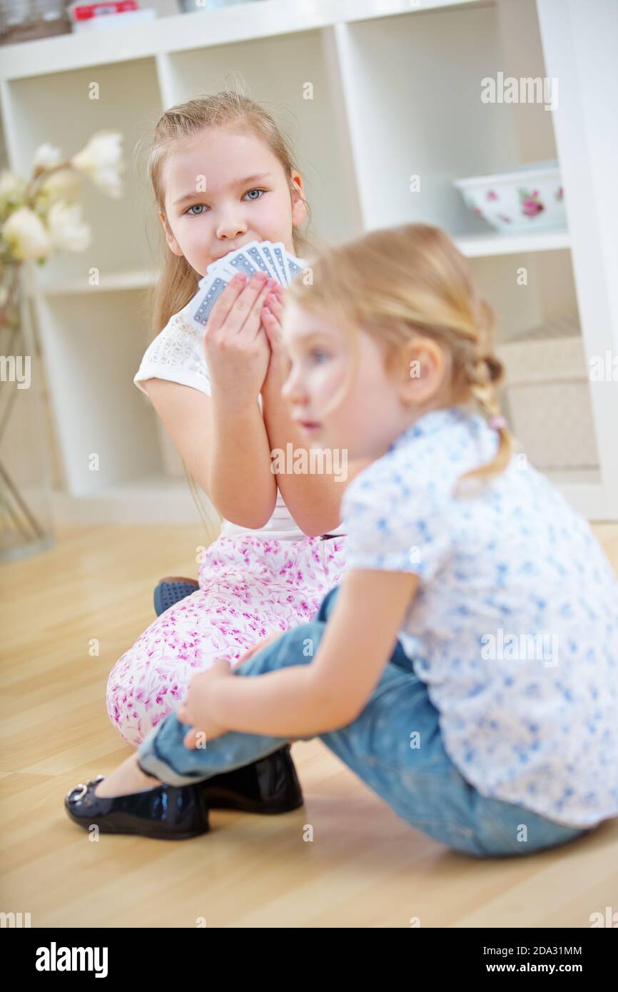 Two children play cards together at home Stock Photo Alamy