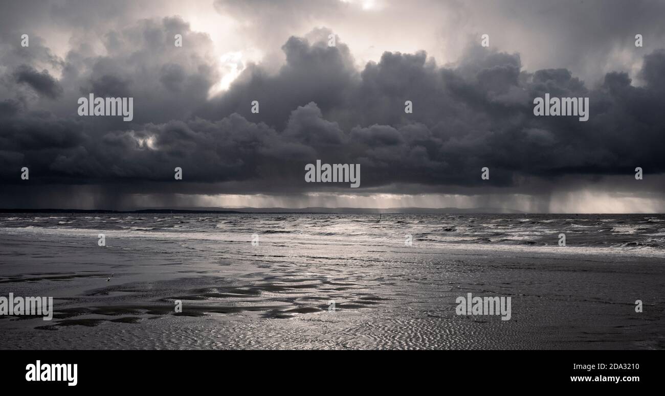 Storm and rain clouds looking out on the Irish Sea from the Liverpool and Sefton beach and coastline. Stock Photo