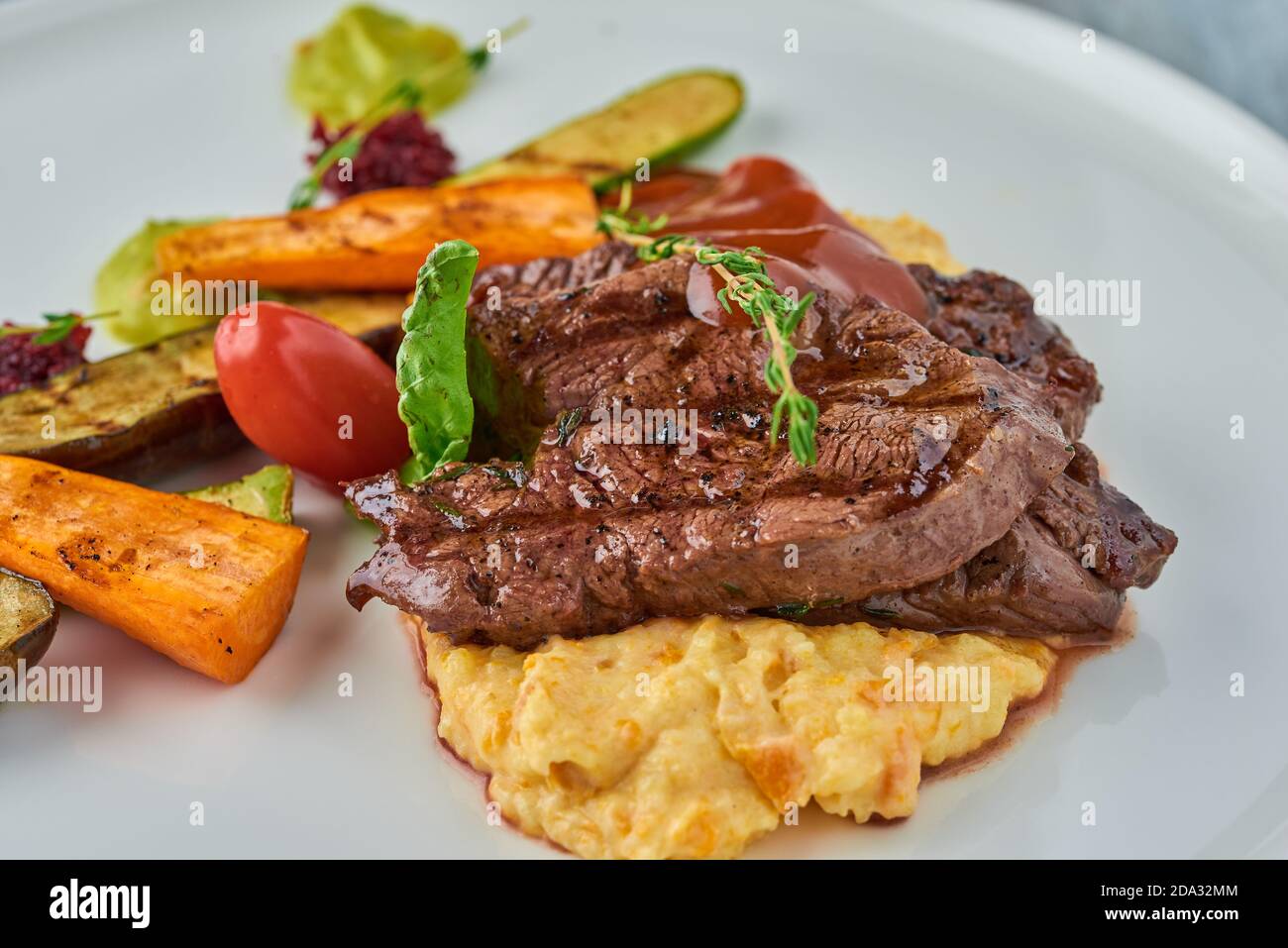 Grilled steak on mashed potatoes with grilled vegetables. Stock Photo