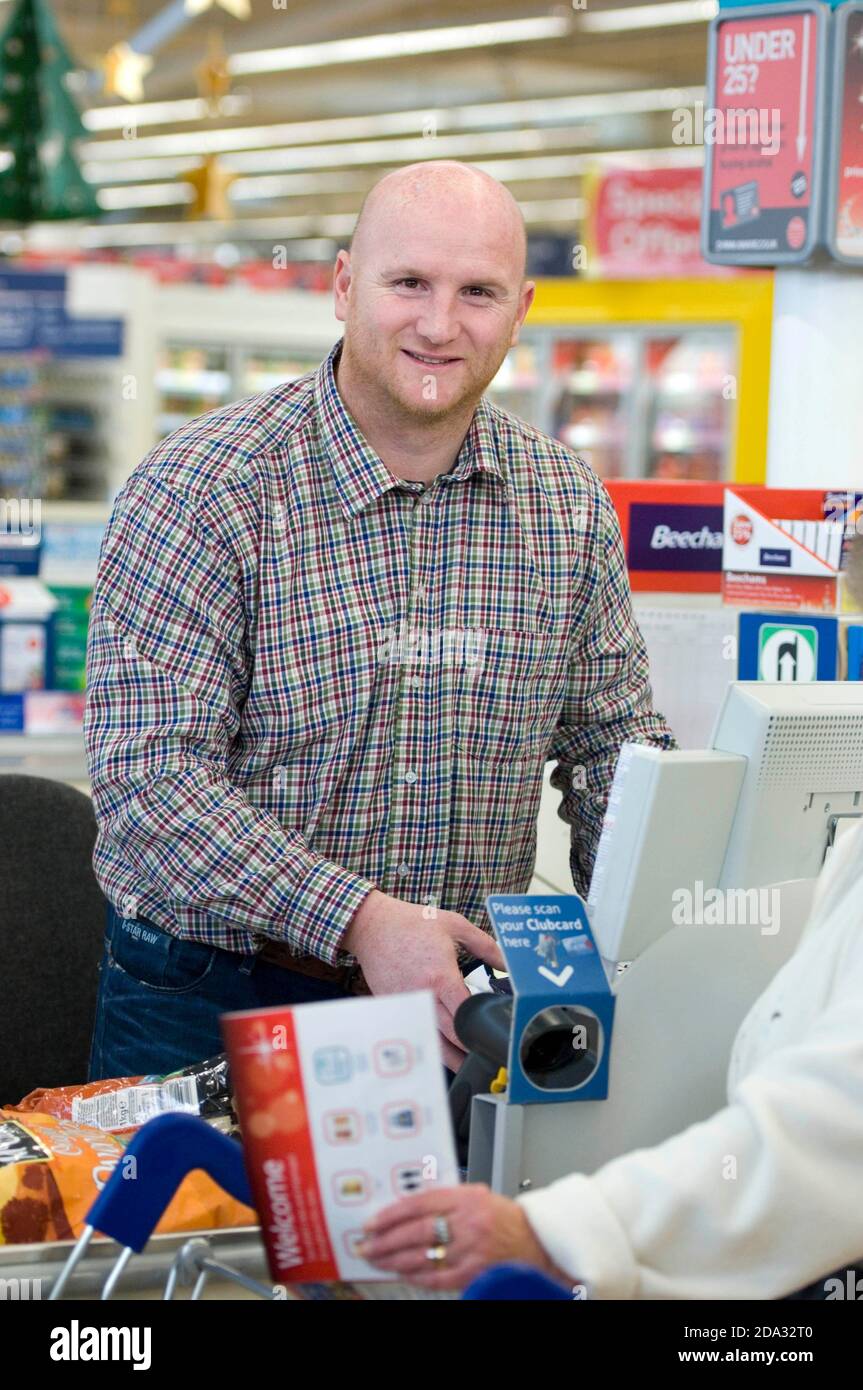 Former Welsh Football International John Hartson tries his hand at serving on the tills at Tesco in Swansea. Stock Photo