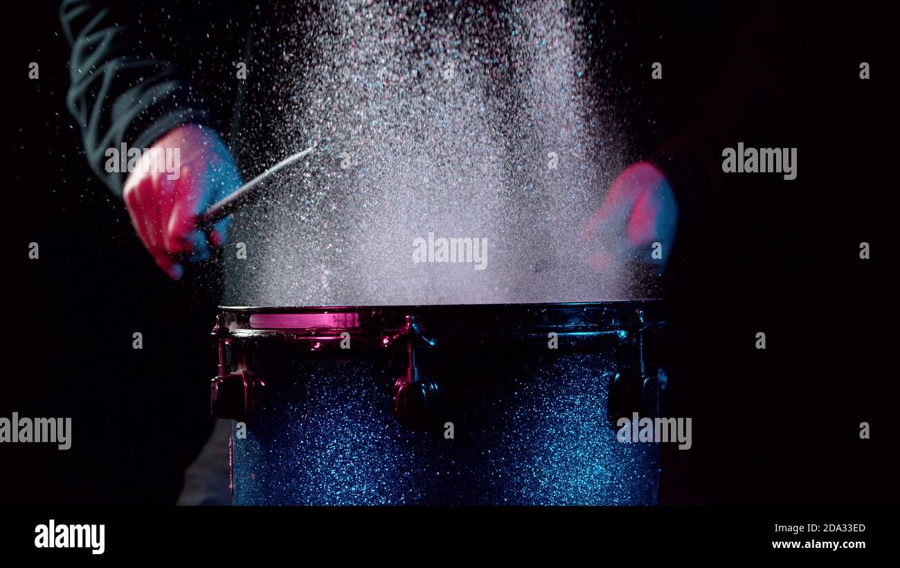 Freeze motion of drummer hitting drum with water splashes, isolated on black background Stock Photo