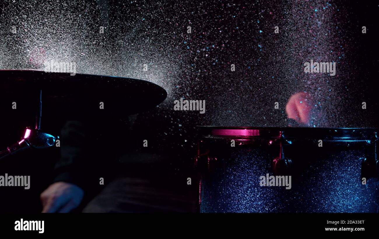 Freeze motion of drummer hitting drums with water splashes, isolated on black background Stock Photo
