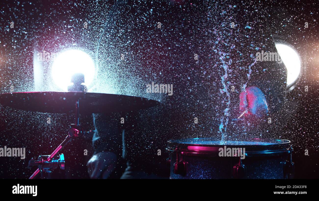 Freeze motion of drummer hitting drums with water splashes, isolated on black background Stock Photo